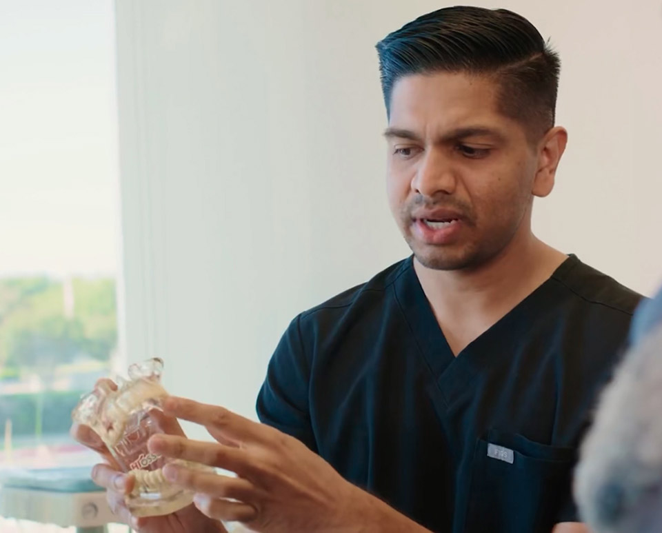 Dr. Shah holding teeth model at Citrus Smiles Dental Studio