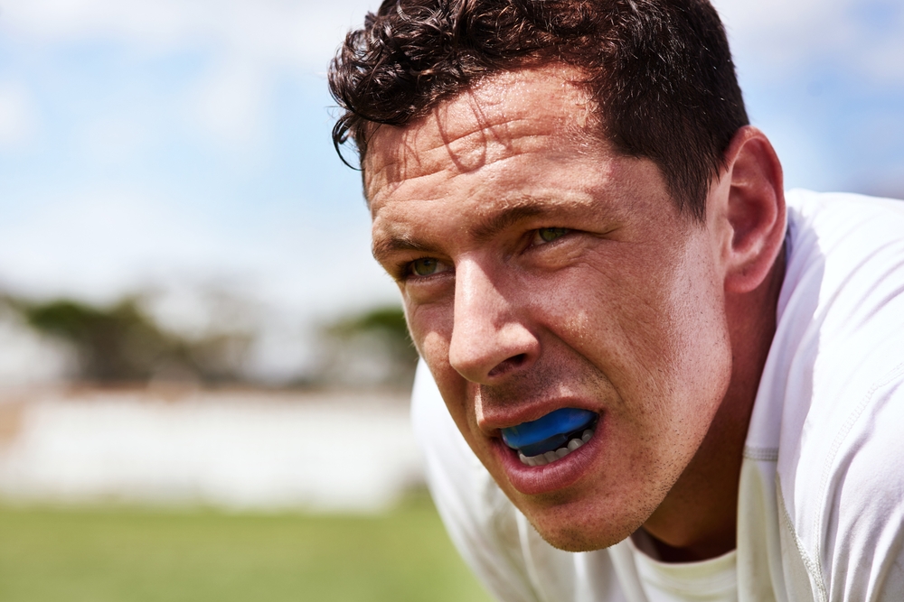 Athlete wearing a blue mouthguard during a sports activity, emphasizing the importance of dental protection in athletics.