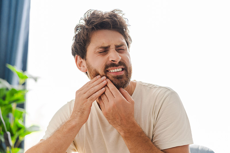 man with mouth pain in need of an emergency dentist